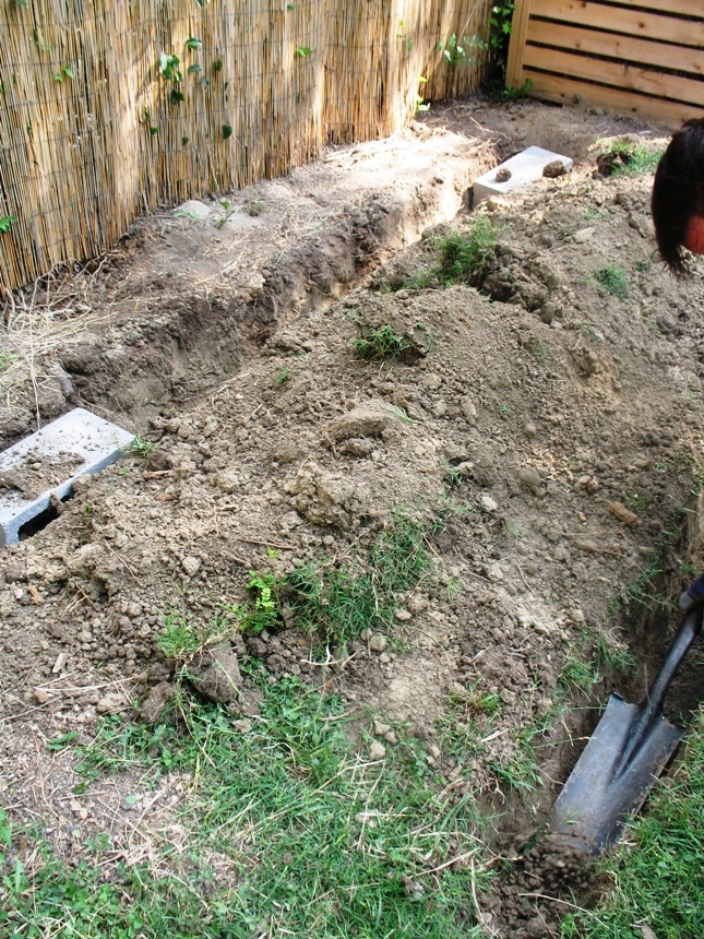 Digging a foundation trench to bury cinder blocks